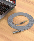 2 Pack Slick 3.5 Mm Aux Extension Cable 6.6 Feet Male To Female Sweet Stereo Sound Adapter on a wooden desk near a laptop.