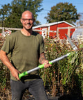 Heavy Duty Stand Up Weed Puller Tool With 40 Inch Handle 3 Claws And Fiberglass Foot Pedal Cast Iron Dandelion Weeder For Easy Weeding Without Bending Or Kneeling Built To Last Like A Boss, man holding it in garden