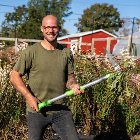 Heavy Duty Stand Up Weed Puller Tool With 40 Inch Handle 3 Claws And Fiberglass Foot Pedal Cast Iron Dandelion Weeder For Easy Weeding Without Bending Or Kneeling Built To Last Like A Boss, man holding it in garden