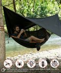 Man relaxing in All In One Camping Hammock With Mosquito Net And Rain Fly Tarp near river, enjoying outdoor adventure.