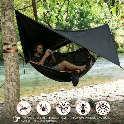 Man relaxing in All In One Camping Hammock With Mosquito Net And Rain Fly Tarp near river, enjoying outdoor adventure.