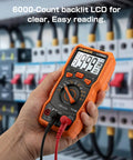 Hand holding 6000-Count Auto-Ranging LCR Meter Multimeter with backlit LCD, in electronics setup.