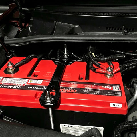 Badass 18-8 Stainless Steel J Hook Battery Hold Down Bolts Kit securing a red battery in an engine bay with trimmable rods.