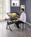Artist using Adjustable Drafting Desk With Stool Multifunction Artist Table For Home Studio Tilting Glass Top Work Surface