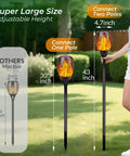 Lit Solar Torch Lights Outdoor With Realistic Flickering Flame 96 LED High Brightness 43 Inch Tall Waterproof Garden Pathway Torches Adjustable Height From 30 To 43 Inches 4 Pack shown with adjustable height feature in garden.