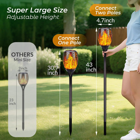 Lit Solar Torch Lights Outdoor With Realistic Flickering Flame 96 LED High Brightness 43 Inch Tall Waterproof Garden Pathway Torches Adjustable Height From 30 To 43 Inches 4 Pack shown with adjustable height feature in garden.