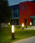 Landscape Path Light 32 Inch Outdoor Bollard Aluminum 8W 800LM LED Lighting For Lawn Patio Courtyard Driveway And Garden Weatherproof Frosted Finish Wired 100 240V Residential Outdoor Lighting illuminating a pathway at night.