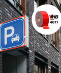 VHB double-sided acrylic foam tape 4611 dark gray used for parking sign mounting on building exterior.