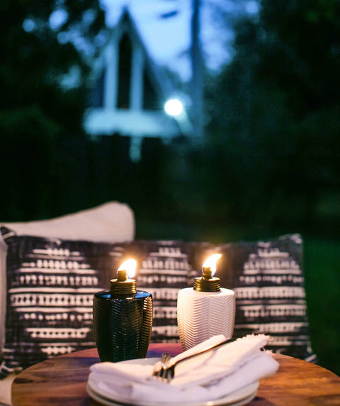 Glass Table Torch Set For Outdoor Patio Vibe, Herringbone Blue 3-Pack on wooden table, night setting, stylish backyard decor.