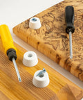 Round Synthetic Rubber Feet Bumpers With Built Threaded Screws on wooden cutting boards with screwdrivers.