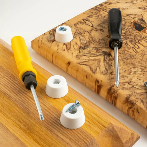 Round Synthetic Rubber Feet Bumpers With Built Threaded Screws on wooden cutting boards with screwdrivers.