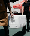 People carrying Beast Mode Heavy Duty 120 Qt Polar Cooler With UV Shield Lid Odor And Stain Resistant Liner Threaded Drain Plug outdoors