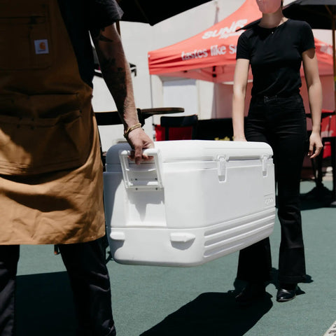People carrying Beast Mode Heavy Duty 120 Qt Polar Cooler With UV Shield Lid Odor And Stain Resistant Liner Threaded Drain Plug outdoors