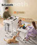 Flex Your Workspace Routine With This Slick Rollaway Standing Desk Featuring A Roomy Desktop Pull Out Storage Bin Built In Mug Holder Heavy Duty Side Hooks And Easy Glide Wheels, showing a man, girl, and woman using desks.