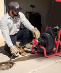 Heavy Duty Workhorse Electric Drain Auger Machine With Automatic Forward And Reverse Footswitch Control Plug And Play Badass Performance For Pro Plumbers One Hundred Feet By Three Eighths Inch Steel Cable Six Sharp Cutters Clears Gnarly Sewer Clogs Smooth in use with operator handling.