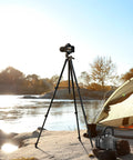 60 Inch Lightweight Travel Camera Tripod For Canon And Nikon DSLRs by a riverside with a tent and kettle, black sturdy alloy