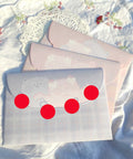 Colorful envelopes with red stickers on a floral tablecloth