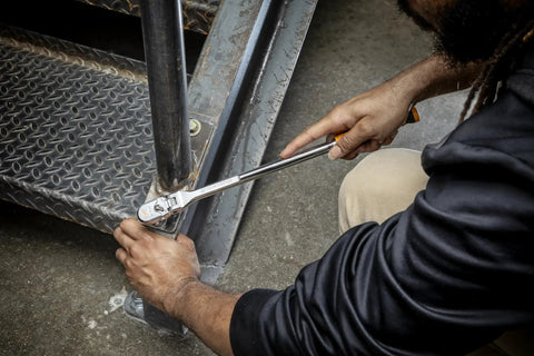 Person using Three Eighths Inch Drive 120XP Flex Head Teardrop Ratchet With Dual Material Handle Built For Tight Spaces And Heavy Duty Fastening Model 81210XP Featuring 60 Tooth Gear And Double Stacked Pawls on metal stairs.