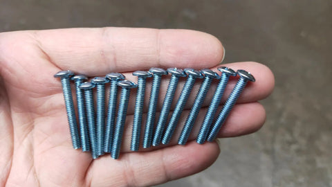 Number 8-32 X 1-1/4 Inch Truss Head Phillips Machine Screws One Pound Bulk Pack held in a hand, showcasing metal screws for DIY projects.