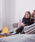 Three Pack Natural Pink Himalayan Salt Lamp With Dimmer Cord And Light Bulb Six To Eight Inch Tall Salt Rock Lamp With Wood Base in cozy room.