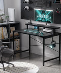 Black compact 31.5 inch computer desk with monitor stand and headphone hook in a small home office setup