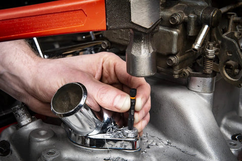 Person using 10 Piece Bolt Biter Screw Extractor Set for stuck fasteners on machinery, bi-directional design, tapered cutting edges.