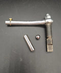 Top view of ZZRSDAN clutch repair kit components: curved silver lever, cylindrical steel rod, small ball, and square-ended shaft