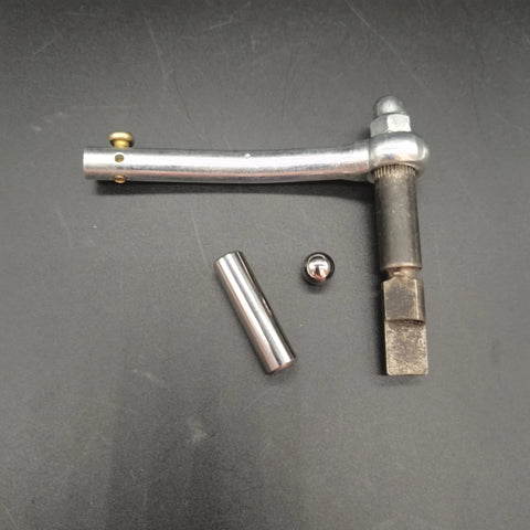 Top view of ZZRSDAN clutch repair kit components: curved silver lever, cylindrical steel rod, small ball, and square-ended shaft