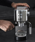 Semi Automatic Espresso Coffee Maker With Built In Steam Wand And High Pressure Pump For Rich Creamy Shots being used on a kitchen counter.