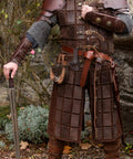 Heavy Duty Medieval Sword Belt And Scabbard Set For Knights Straight Up Classic Reenactment Wear That Goes Hard Legit Leather Build In Black Or Brown That Holds Its Ground For Folks Prepping For The Big Festival, worn with chainmail and holding a sword.