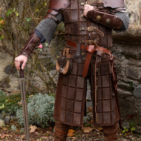 Heavy Duty Medieval Sword Belt And Scabbard Set For Knights Straight Up Classic Reenactment Wear That Goes Hard Legit Leather Build In Black Or Brown That Holds Its Ground For Folks Prepping For The Big Festival, worn with chainmail and holding a sword.