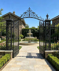 Ornate iron gate in garden setting showcasing Beefy Barrel Gate Hinge Set For Outdoor Use Heavy Duty Weld On Hinges for durability.