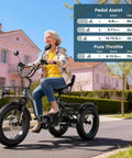 Electric Tricycle For Adults With Fat 4 Inch Tires Foldable Aluminum Frame 400 Pound Capacity Large Rear Basket 500W Motor Compact Folded Size 40X42X29 Hauling Groceries And Weekend Cruising, woman riding black fat-tire trike on a neighborhood street