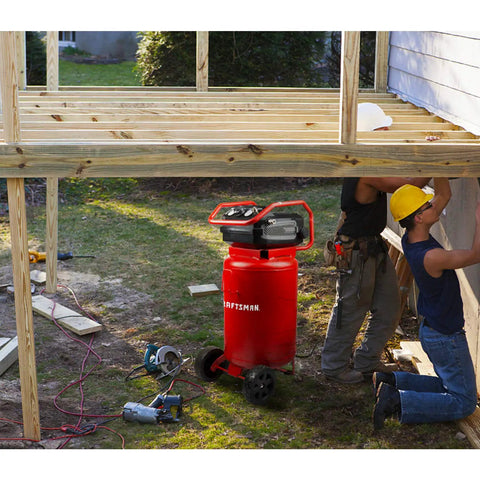 20 Gallon Oil Free Air Compressor With 1.8 HP Motor Pushing A Full 175 PSI dual quick couplers in vibrant red at a construction site.