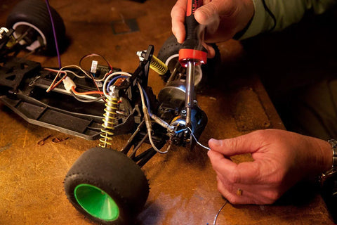 Person using 80 Watt LED Soldering Iron With Three 5mm High Temperature LEDs At 25 Lumens Per Sq Ft For Superior Visibility And Precision Soldering Up To 900F With A Co Molded Soft Grip Non Slip Handle Ideal For Electronics DIY Projects to repair small vehicle circuits