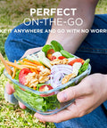 Person holding a salad in a 35 Piece Glass Food Storage Set With Airtight Lids For Easy Meal Prep BPA Free Leak Proof Bento Boxes.