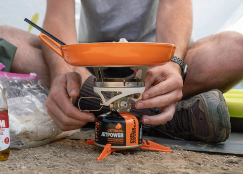 Summit Skillet Nonstick Camping Cookware on backpacking stove, ceramic-coated pan with orange handle, outdoors, easy setup