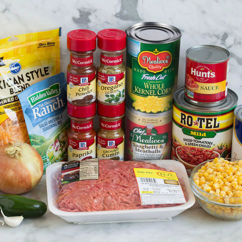 Groceries and ingredients including Hidden Valley Ranch, spices, whole kernel corn can, and meat on a countertop.