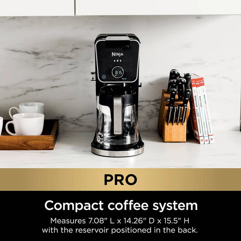 Hot And Iced Coffee Maker With All In One Dual Brew Pro System on kitchen counter, compact design with black finish, near cups and knives.