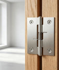 Close-up of Set Of Four 2 Inch Stainless Steel Spring Hinges Self Closing for doors, mounted on wood, showcasing spring mechanism.