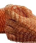 Hand holding Sturdy Pure Copper Wool Mouse Blocker Mesh 4 Inch By 40 Inch for rodent proofing home and garage.
