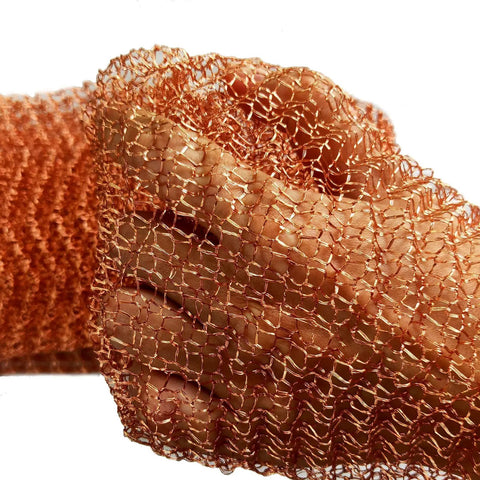 Hand holding Sturdy Pure Copper Wool Mouse Blocker Mesh 4 Inch By 40 Inch for rodent proofing home and garage.