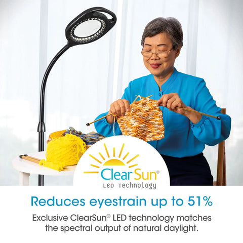 Two In One ClearSun LED Magnifier Light Floor And Table Lamp For Crafting Sewing Reading And Needlework Hands Free Optical Grade Magnification With Bright Natural Light For Your DIY Projects, showing a person knitting under the lamp.
