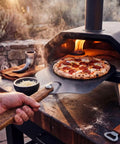 Viking Style Pizza Peel With Cutter Rocker, Heavy Duty Metal Paddle 14x12 Inches, Foldable Wood Handle in outdoor oven use