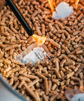 Close-up of Bonfire Pellet Adapter For Outdoor Fire Pits Dual Fuel Upgrade in use with wood pellets burning in stainless steel extension.
