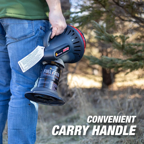Person holding Little Buddy Portable Radiant Propane Heater, convenient carry handle visible, outdoors in a wooded area.