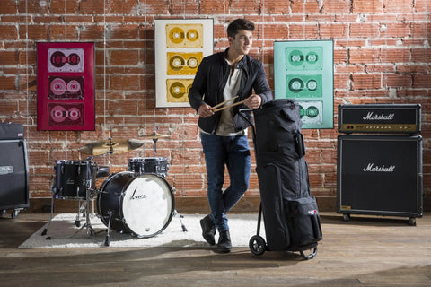 Heavy Duty Rolling Drum Cart With Removable Nylon Gear Bag And Tough Steel Frame, held by a drummer in a studio setting.