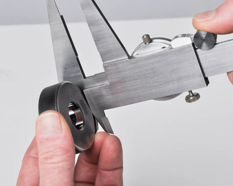 Dial Caliper With 0-6 Inch Range, Precision To 0.001 Inch, measuring metal part, focus on knurled lock and dial, durable black body