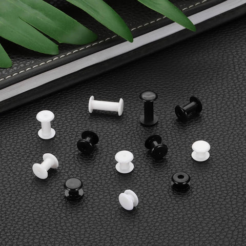 Top Shelf Black Plastic Chicago Screws 50 Piece Set Binding Posts M5x3mm Press On Buckles on black leather background.