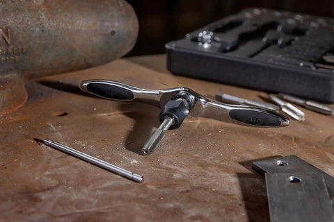 Close-up of ergonomic T handle from 27 Piece Metric Ratcheting Tap And Die Set With 72-Tooth Fine Ratchet, 5 Degree Swing, visible on a workbench